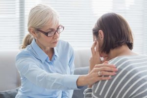 A therapist comforts a client in an addiction therapy program